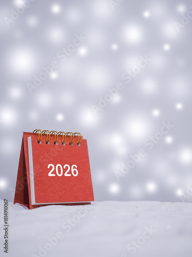 2026 desk calendar with shiny light for Christmas and New Year holidays background, Winter season, falling snow, Copy space for Christmas and New Year holidays greeting card.