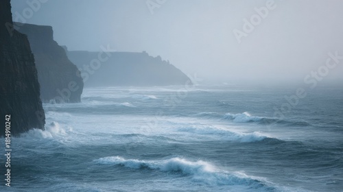 Landscape photograph of a rocky coastline. the sky is overcast and the water is choppy with large waves crashing against the cliffs.
