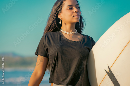 Photography Portrait of an ethnic Surfer Woman holding a surfboard
