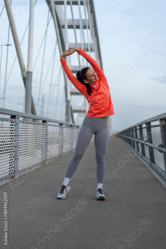 Woman stretching on a bridge before a morning workout session