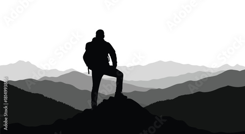 Silhouette of a hiker standing atop a peak overlooking layered mountains