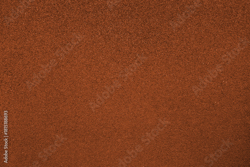 Close-up texture of an orange athletics running track surface. Detailed rubberized sports surface with uniform grain and clean color, ideal for sports and fitness designs, athletics concepts.