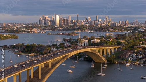 The Gladesville bridge over the Parramatta river with the city of Sydney in the background.
