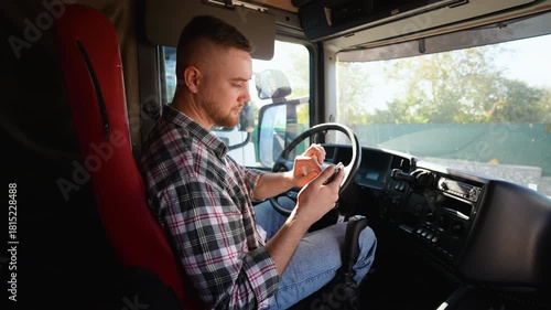 Truck driver using smartphone inside lorry cabin