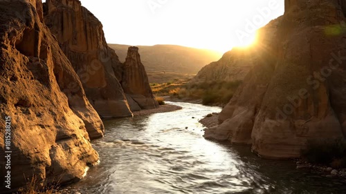 Golden sunset over majestic river, rugged canyon rock formations, awe inspiring landscape, serene nature outdoors, tranquil panorama