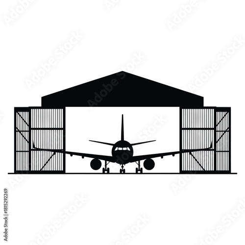 Silhouette of an airplane inside an open hangar at dusk