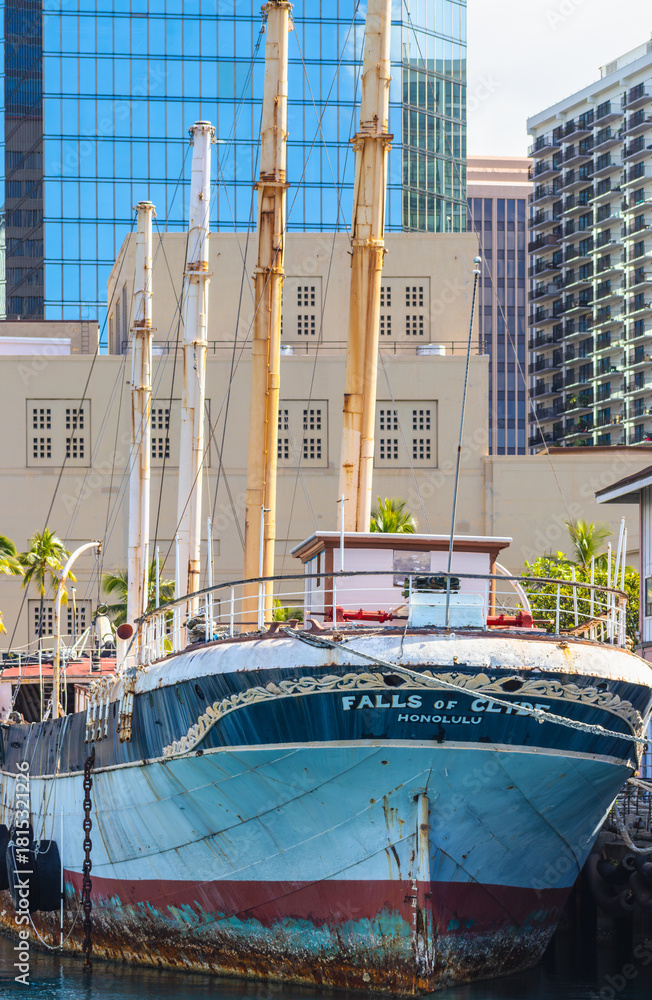 Fototapeta premium The Falls of Clyde ship, the last sail-powered oil tanker, in dock along Aloha Tower Drive on February 26, 2024, now scuttled, sunk by the Hawaii Dept of Transportation in October of the same year.