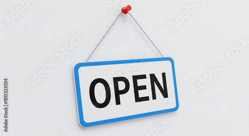 A white 'Open' sign hangs on a white wall, indicating a business is ready for customers. The blue-bordered sign is suspended by a chain and a pushpin