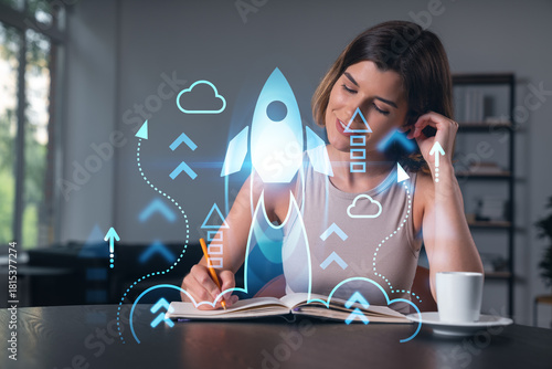 Smiling woman in casual wear taking notes in notebook at office workplace with coffee cup. Concept of distant business education, information technology, dreaming, thinking. Start up drawings