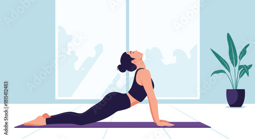 A woman in black activewear performs a yoga cobra pose in a bright room with a potted plant.