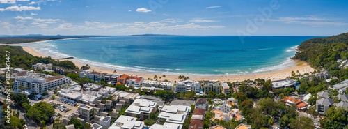 Aerial panorama of a coastal city behind a sandy beach an idyllic blue ocean bay