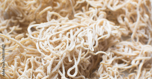 Overhead view of dried homemade egg noodles on a marble countertop, top view of air-dried egg noodles on white background