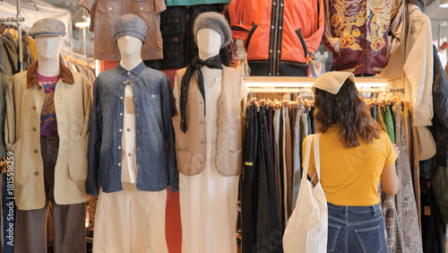 Young teen tourist Gen Z asia female choose look at zero waste eco go green buy second hand sale store flea market thrift old used vintage fabric style. Happy woman city asian people small retail shop