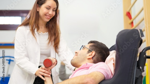 Physiotherapist assisting man with rehabilitation exercise in clinic