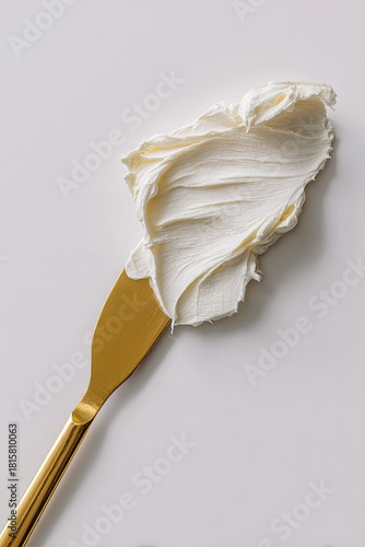 Gold spatula with creamy white frosting