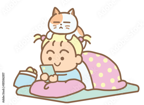 A young girl lies playing with her phone under a warm blanket.