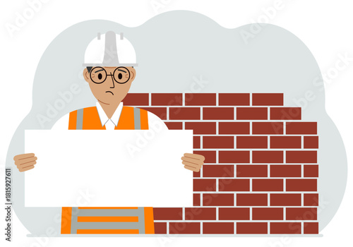 Builder man holding a white sheet of paper for text. Brickwork next to him.