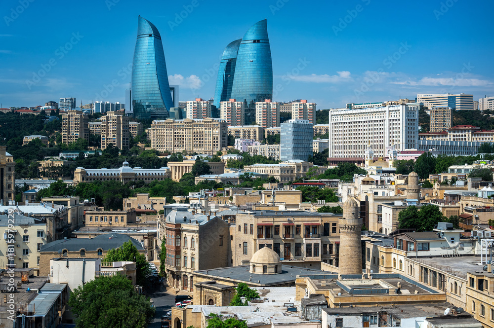 Fototapeta premium Panoramic view of Baku’s old town architecture with modern towers and city buildings in the background under a clear sky.