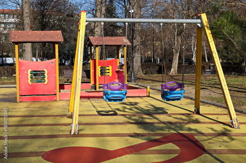 Autumn playground with plastic swings and houses with an abacus in a neighborhood park, Sofia, Bulgaria