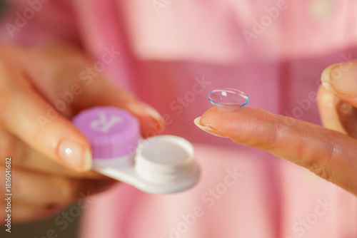 Fotografie Soft contact lens on fingertip with storage case for modern eye vision correctio