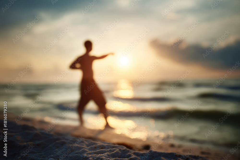 Fototapeta premium Blurred man stretching on sandy beach at sunrise, ocean waves in background, peaceful and energetic atmosphere, early morning exercise, healthy lifestyle, silhouette