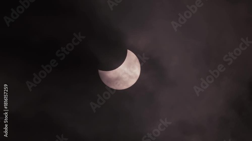 Solar Eclipse with Dramatic Dark Clouds Moving Across Partially Eclipsed Sun