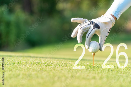Close up hand Golfer woman putting golf ball for Happy New Year 2026 on the green golf for new healthy.  copy space. Healthy and Holiday Concept
