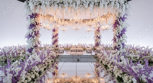 Purple and white floral archway is reflected, bright lighting, Indian wedding decoration. Use as a romantic backdrop, product photography, or social media design.