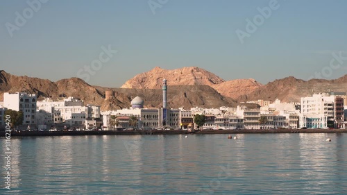 View of Mutrah Corniche with coastal road, buildings and rocky hills
