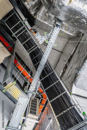 Close-up of industrial electrical installations and cable trays. Intricate network of power cables and wires for industrial or commercial infrastructure.