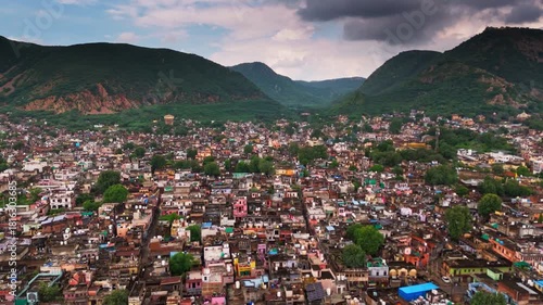 Top-angle drone shot of Alwar city blending greenery with Aravalli hills.