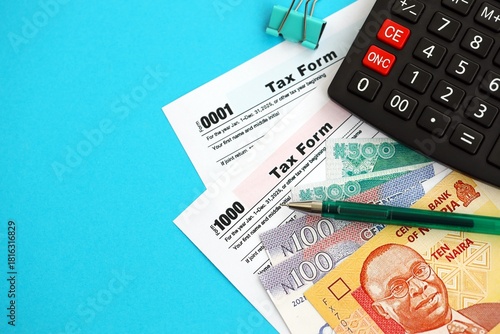 Nigerian naira money bills and calculator with tax form close up. Taxation and accounting concept