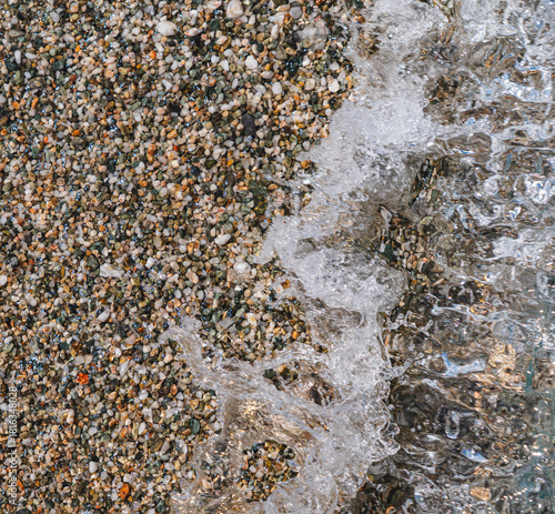 close-up of ocean waves crashing onto a pebble beach