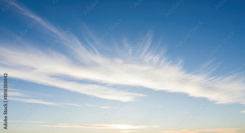 Obraz premium Clear Blue Sky with Wispy White Cirrus Clouds and Gentle Horizon Light