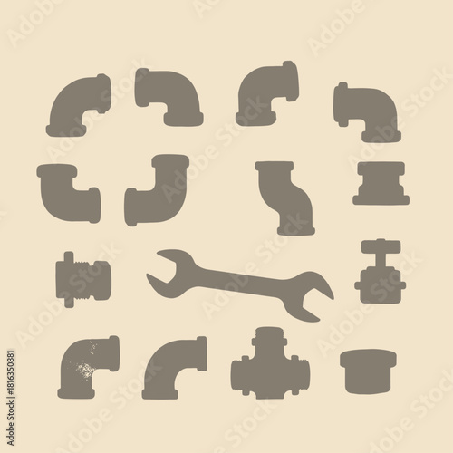 Collection of various plumbing pipe fittings and a wrench arranged on a beige background.