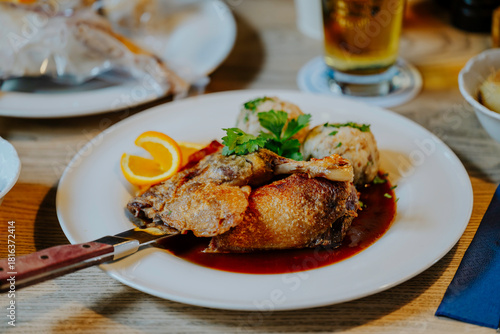 Knusprig gebratene Ente mit goldbrauner Haut, Serviettenknödeln und Bratensoße – festliches Weihnachtsgericht auf dem Teller