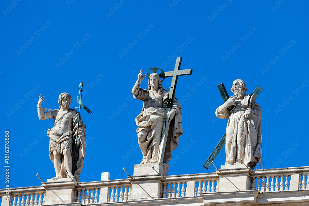 Obraz premium St. Peter’s Basilica.John The Baptist, Jésus, Saint Andrew,Statues of Christ, John the Baptist, and an apostle holding crosses crown Saint Peter’s Basilica façade.