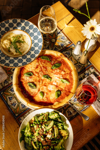 Pizza pasta salad and wine on the table in a restaurant in Italy