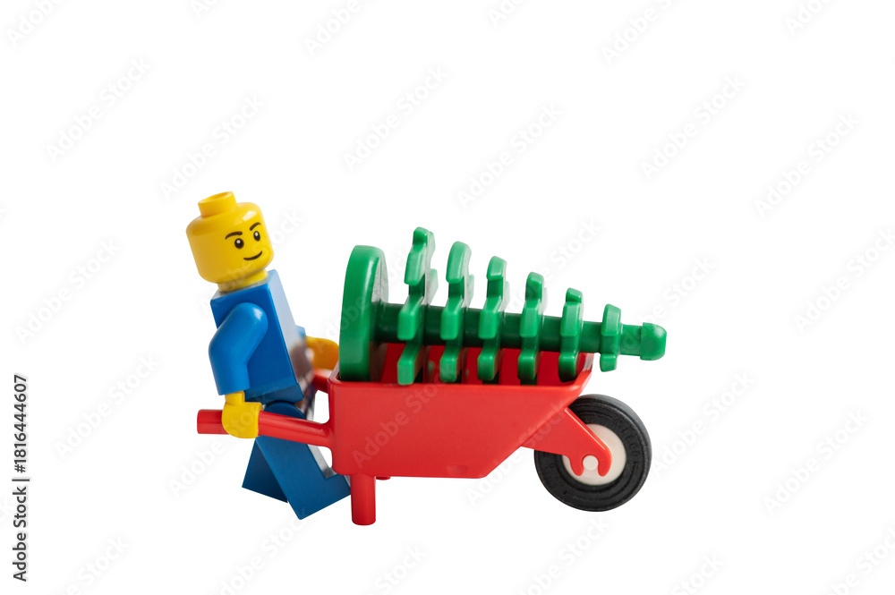 Naklejka premium Lego man pushing a wheelbarrow isolated on white background.