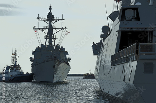 GUIDED MISSILE DESTROYER - US Navy ship maneuvers in the port assisted by a tugboat 