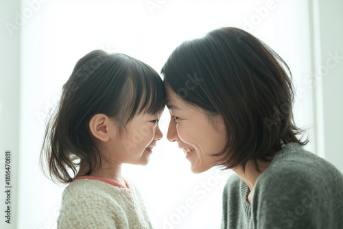 優しい光の中で額を寄せ合う母娘の微笑ましいひととき