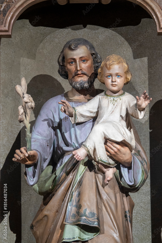 Naklejka premium Statue (19th century) of Saint Joseph holding baby Jesus Christ in his arms.
