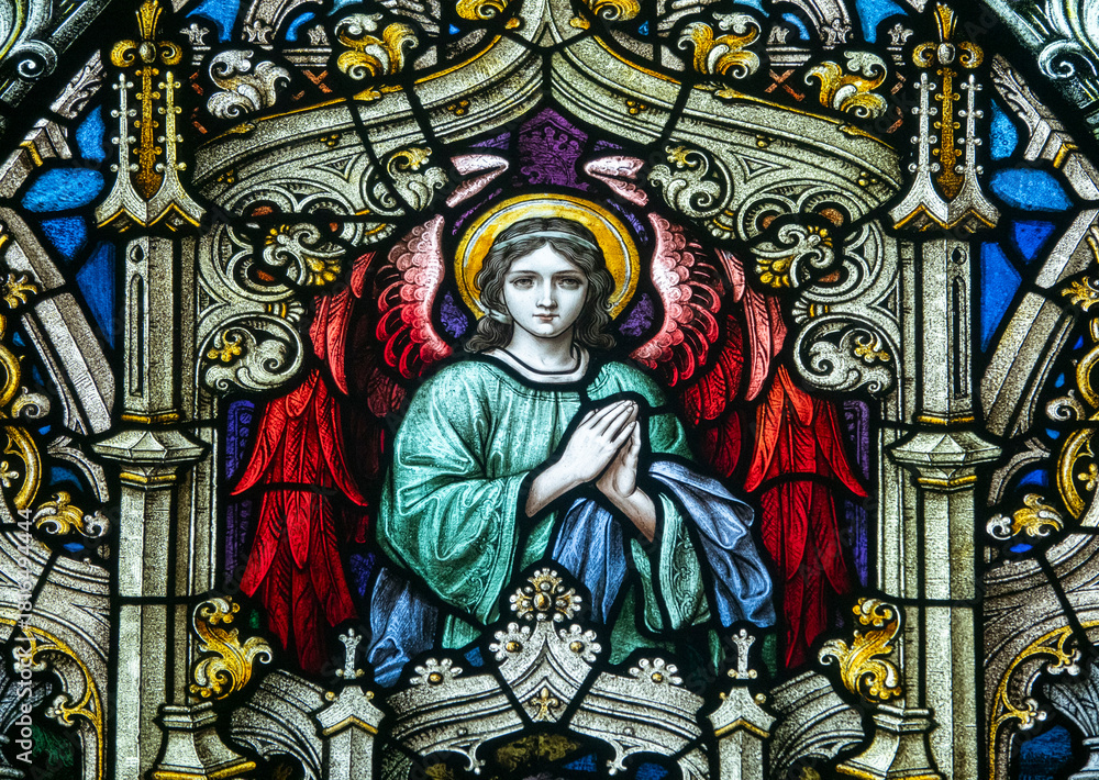 Fototapeta premium Stained glass (19th century) of an angel in adoration and prayer.