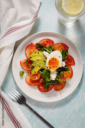 Fresh salad with tomatoes and boiled egg on white plate, healthy meal 