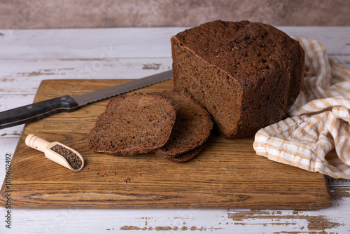 Rye Borodino (Borodinskiy) bread with a crispy crust on a wooden board, cut into slices. Homemade baking in rustic style. Selective focus, close-up.