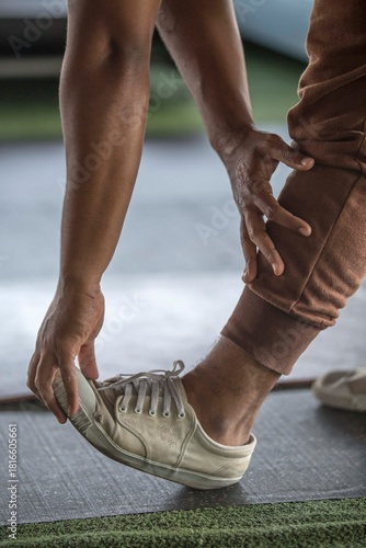 Close-Up of man Athlete Stretching Calf Muscle Pulling Foot in Gym Workout