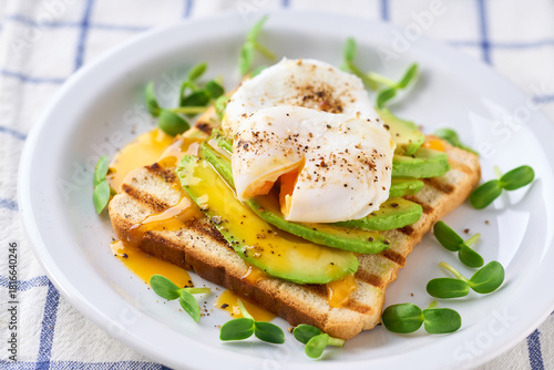 Breakfast with poached egg toast with avocado, vegetarian food.Healthy sandwich with avocado and poached eggs.