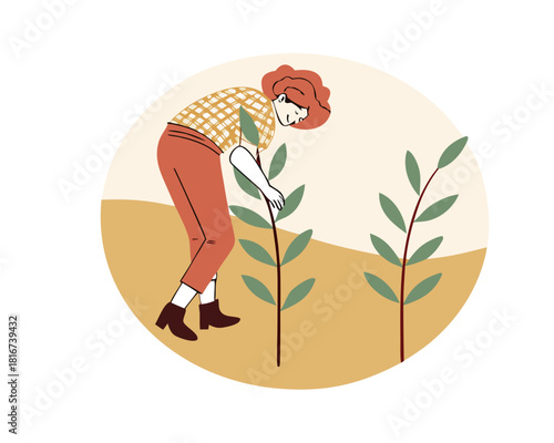 Farmer woman tending and caring for young crops in a field