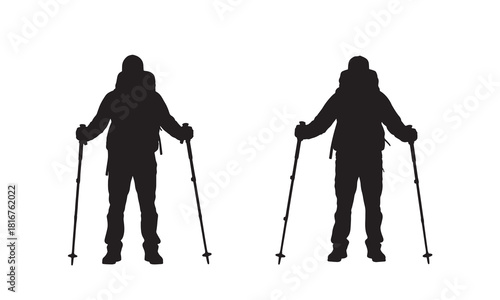 Two hikers with backpacks and trekking poles silhouette