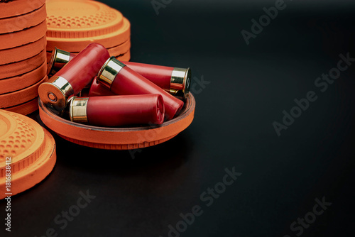 Clay disc flying targets and shotgun bullets on black background ,Clay Pigeon target
